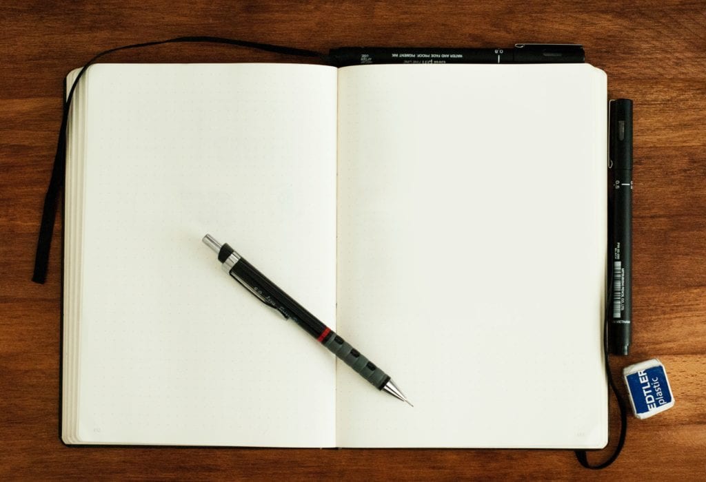 open journal with blank pages and pen